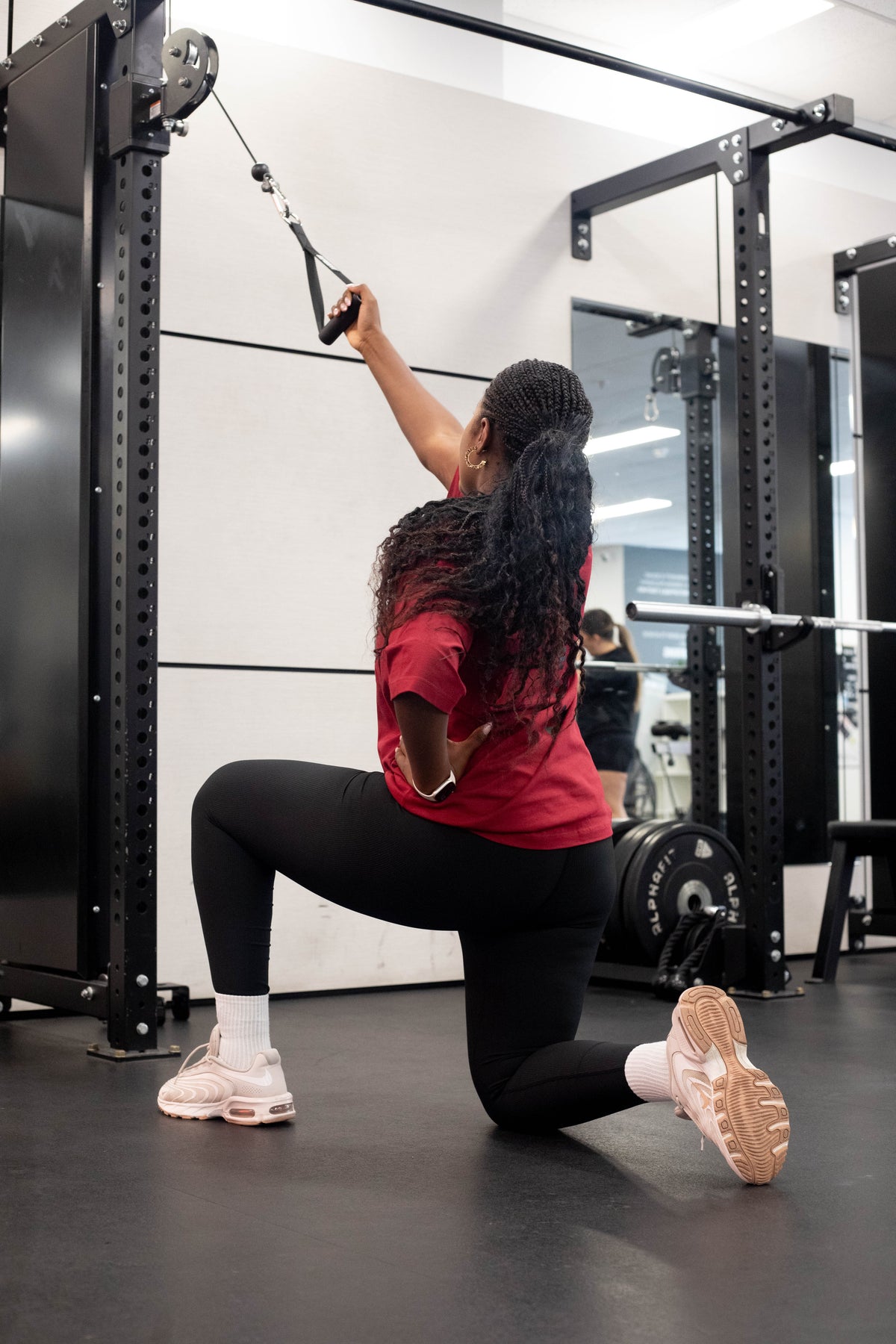 Woman doing a kneeling cable row in a Core Form Apparel tee