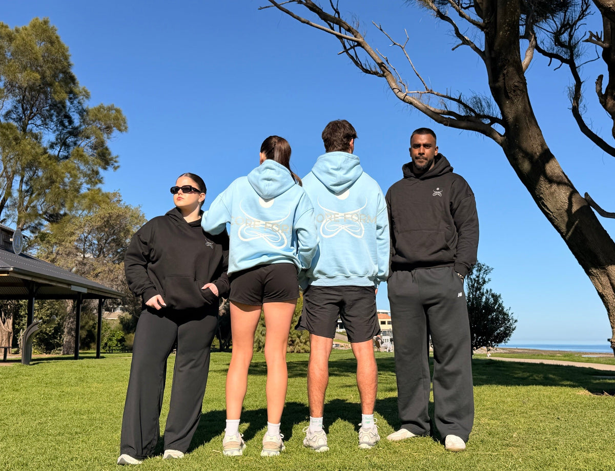 Group wearing Core Form Apparel hoodies by the beach